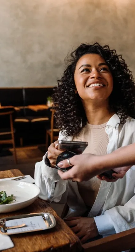 A guest paying by contactless tap at the table