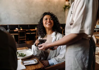 A guest paying by card at the table